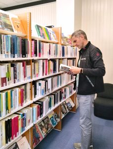Immersion à la médiathèque de Flers - Homme devant un rayon de livres
